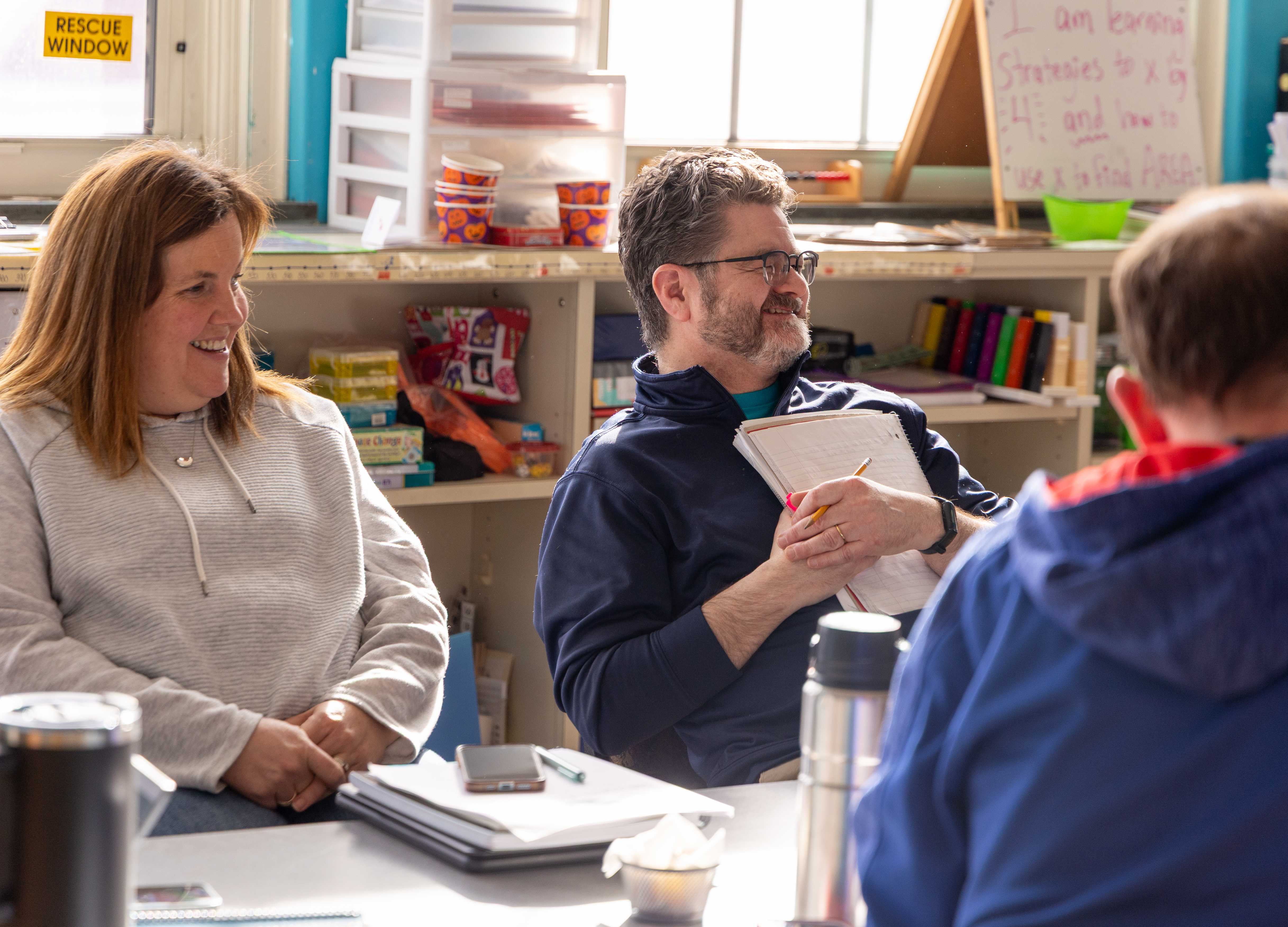 A couple of faculty members smile to the front of the classroom